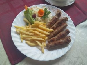 Serbian Ćevapi Served with Chips and Salad